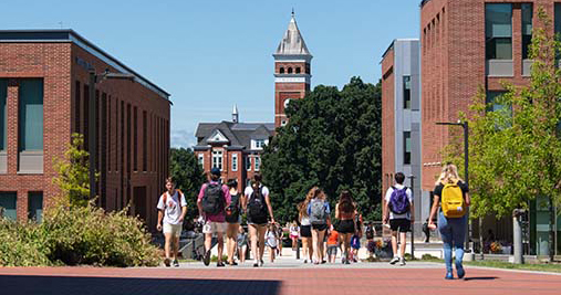 Students walking at Douthit with a view of the Tillman Clock in the background.