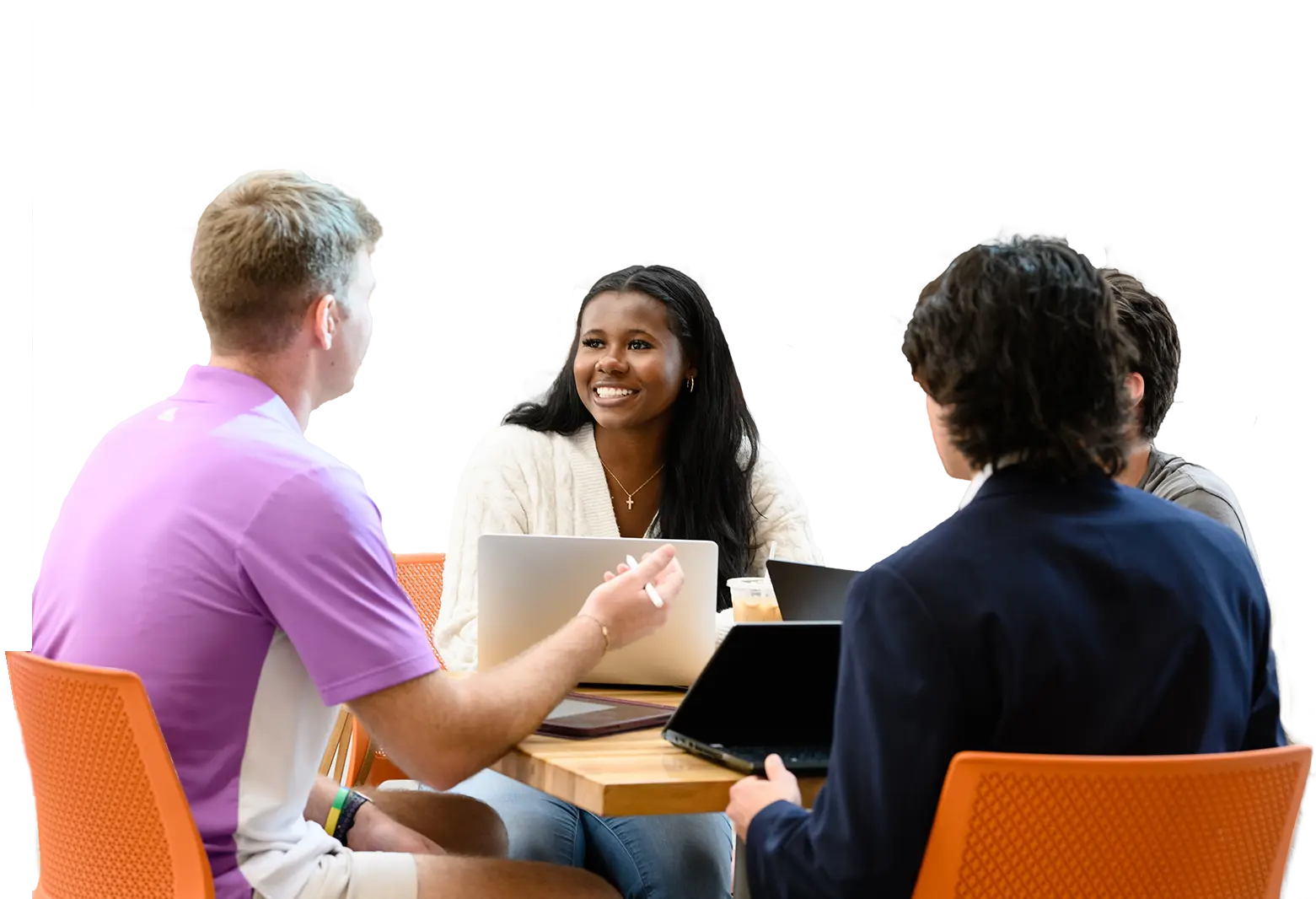 Students sit at a table with their laptops
