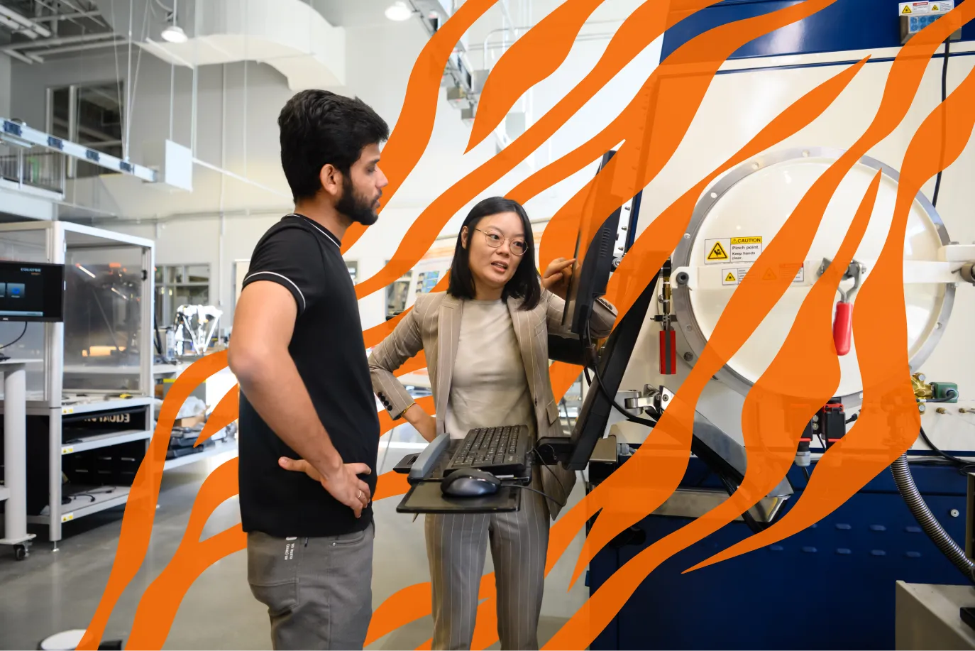 Two researchers in a lab look at a computer screen with an orange Tiger stripe overlay.