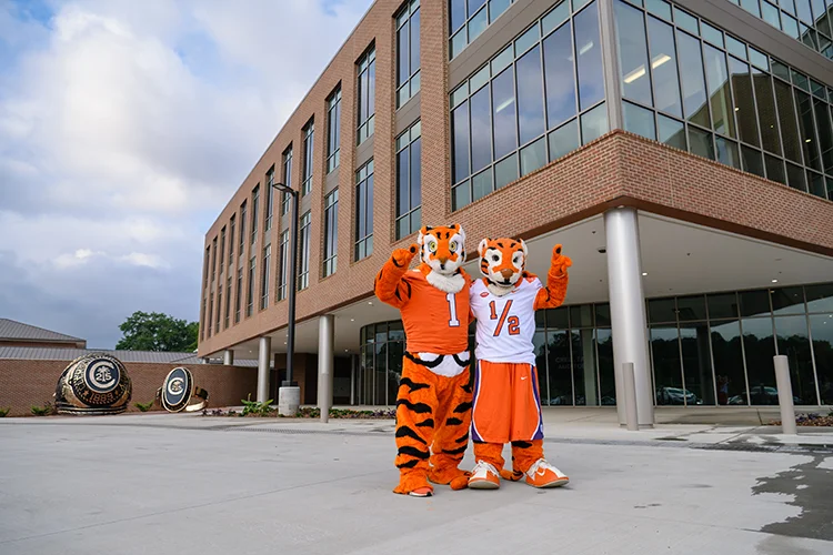 The tiger and cub mascots stand in front of the Nieri Family Alumni and Visitors Center