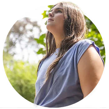 A female student wearing a gray-purple sleeveless top looks up.