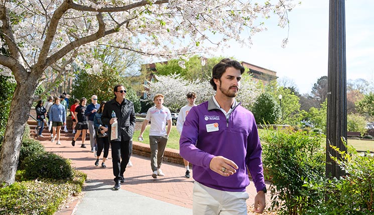A tour guide leads a group around campus.