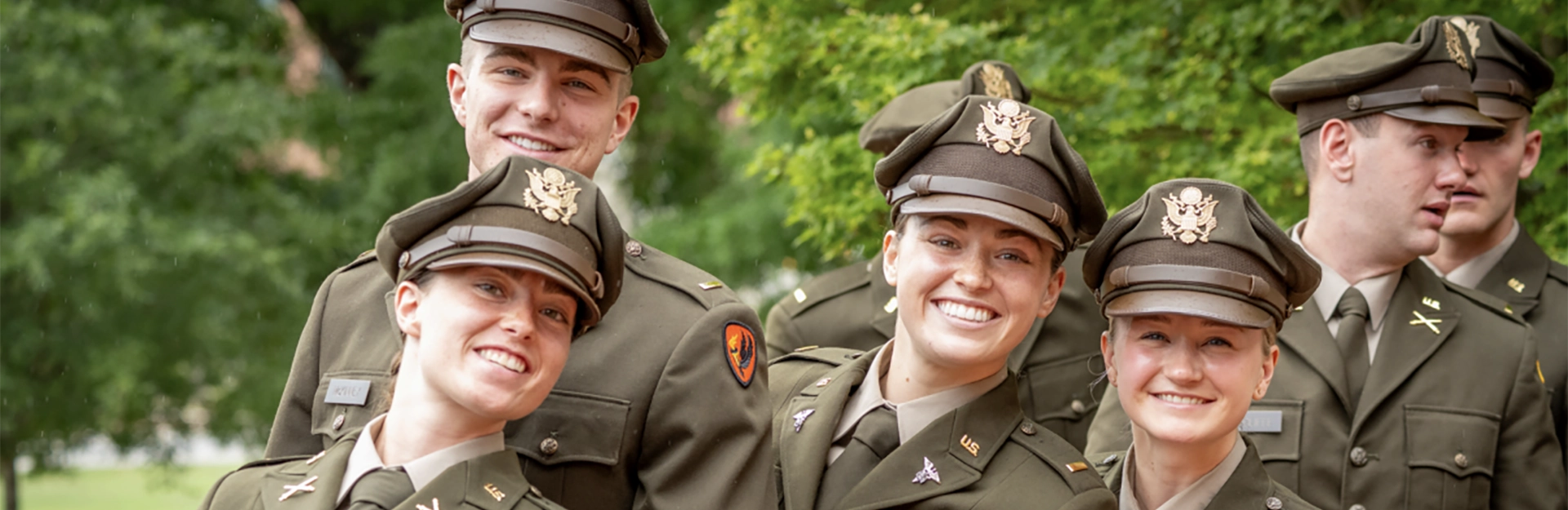 Man and woman in Army dress uniform facing each other and saluting one another.