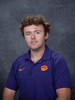 Portrait of a man wearing a purple Clemson University polo shirt with a tiger paw logo.