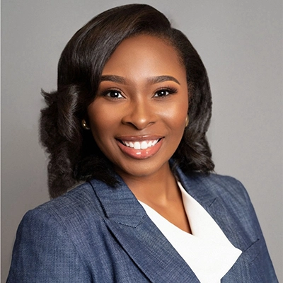 Professional headshot of a smiling African American woman in a blue blazer.