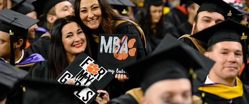 Two professionals collaborating at an outdoor table, focusing on a laptop.
