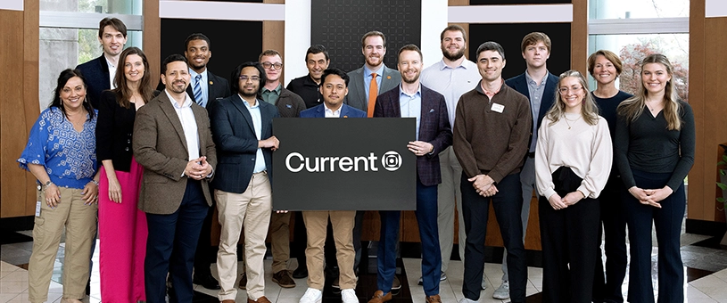 Group photo of Current team members holding a sign.