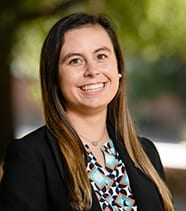 Head shot of female student with long brown hair and black jacket.