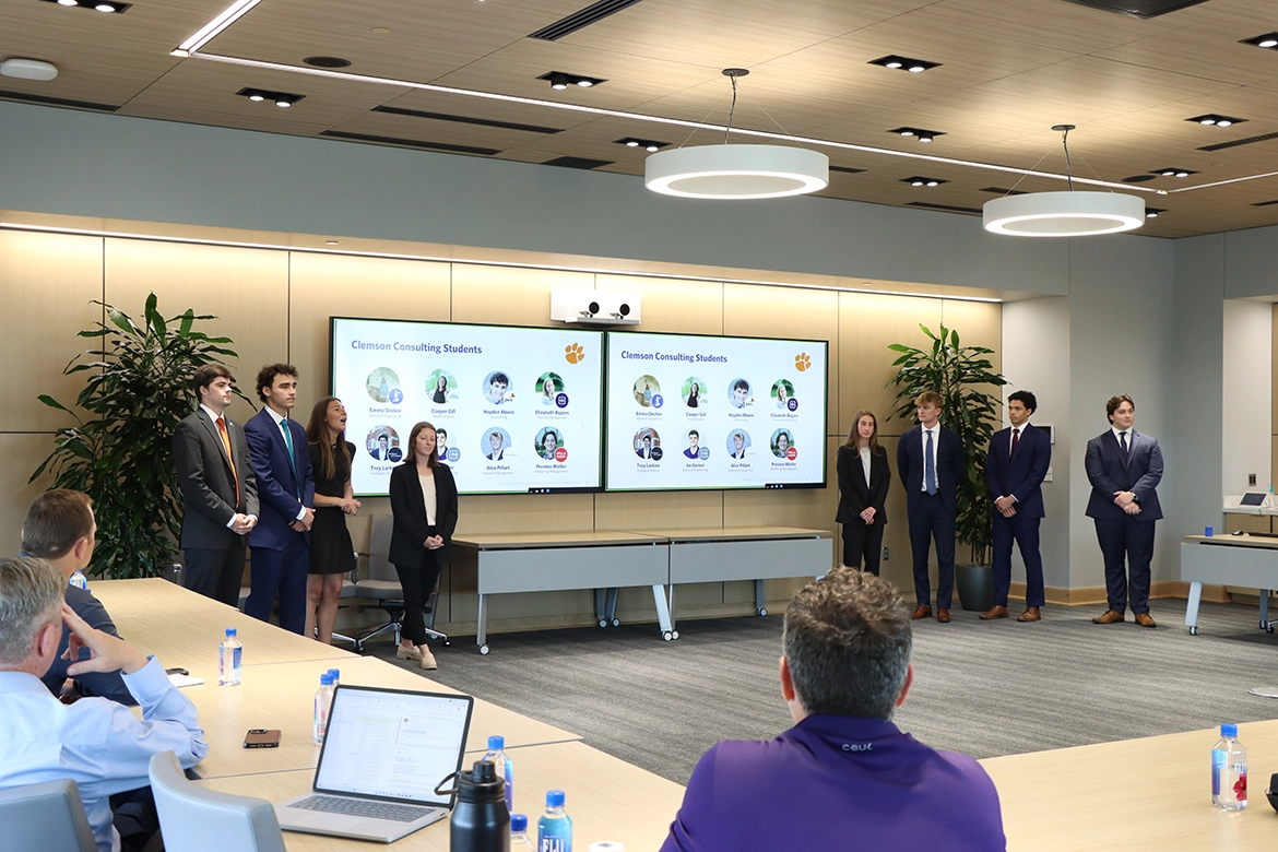 Professionally dressed students giving presentation.