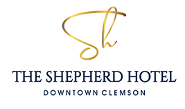 Logo for The Shepherd Hotel, Downtown Clemson, featuring a gold scripted monogram above the name in blue.