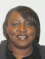 Portrait of a smiling woman with shoulder-length hair, wearing a black shirt.