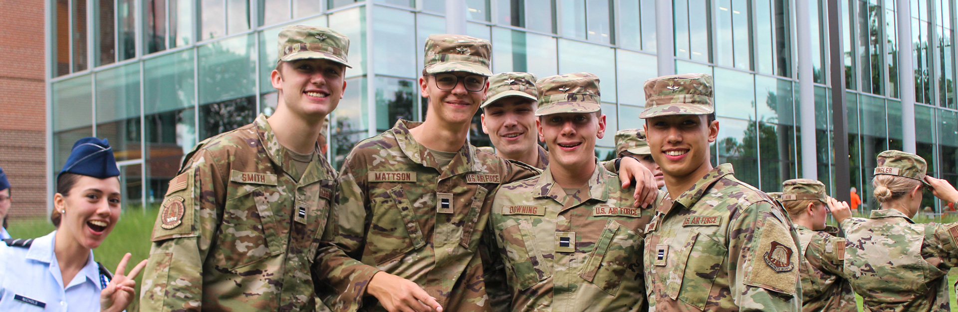 Cadets in camouflage standing together for picture.