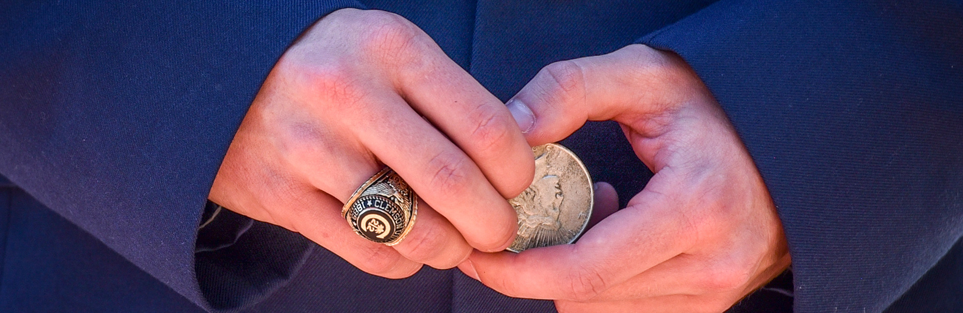 Uniformed person hands holding coin.