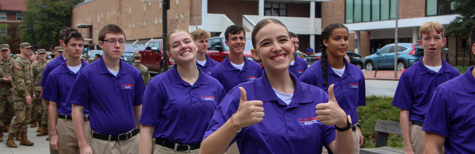 Cadets in purple shirts walking together on campus.