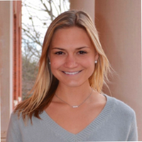 Female with shoulder lenth blonde hair wearing light blue shirt.