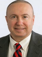 Professional headshot of a man in a suit with a striped tie.
