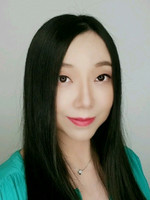 A portrait of a woman with long black hair and a teal blouse, showcasing a friendly expression.
