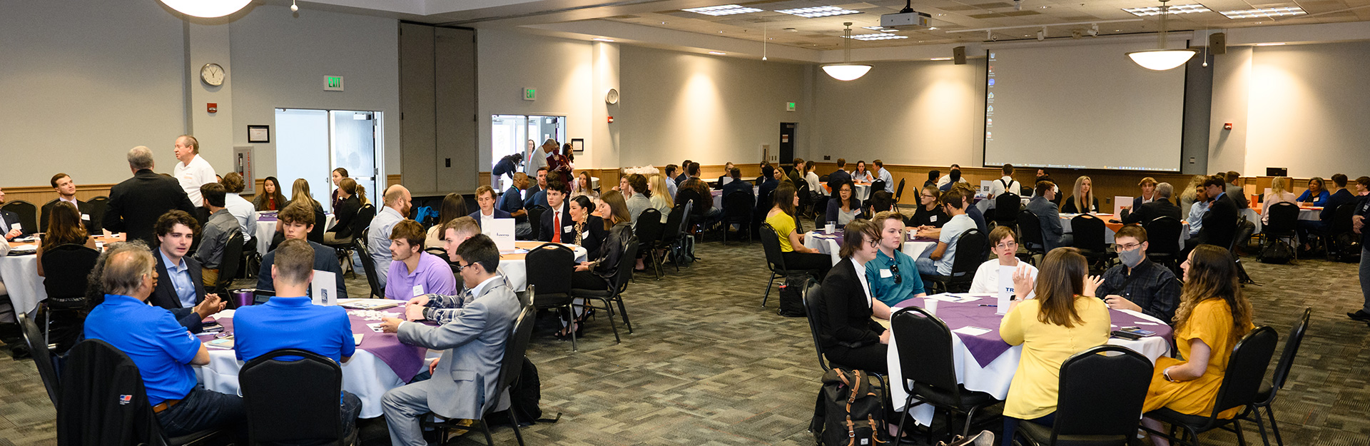 People attending conference sitting at round tables.