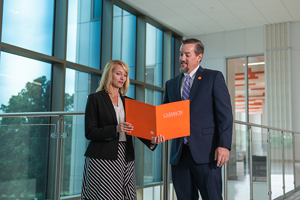 Kristin Scott and Craig Wallace holding College folder.