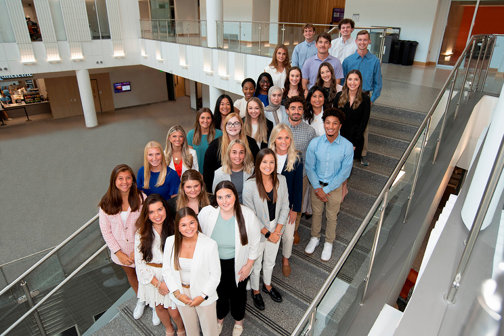 Group of MS Marketing students standing on stairs on Business school.