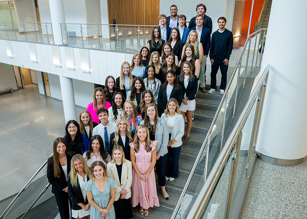 Group of MS Marketing students standing on stairs on Business school.