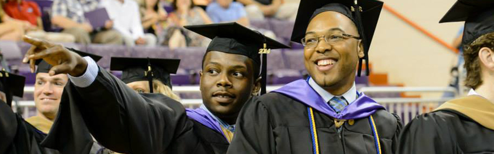 Two males in cap and gown at graduation.