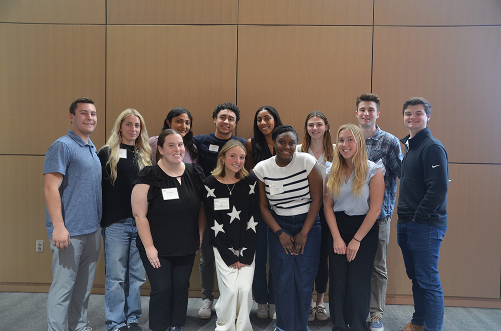 Group photo of students smiling together in a conference setting.