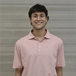 Smiling person wearing a light pink polo shirt, standing against a light gray background.