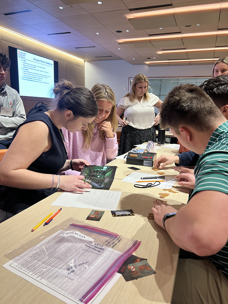 A group of students collaboratively working on an interactive task during a workshop, with various materials spread across the table.