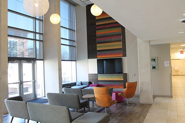 Modern lounge area featuring colorful accent walls, comfortable seating, and large windows for natural light.