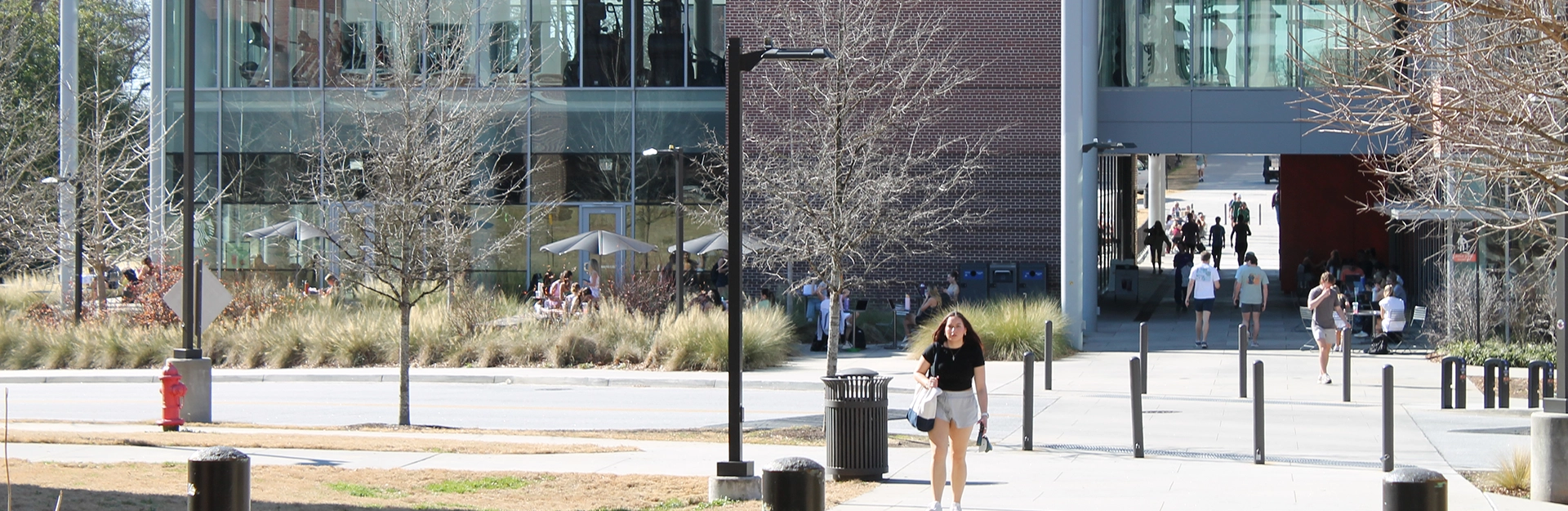 Student walking on campus between buildings