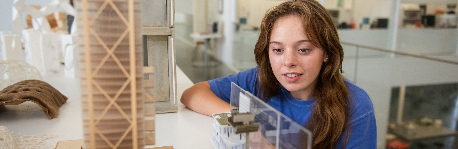 a student examines an architectural model