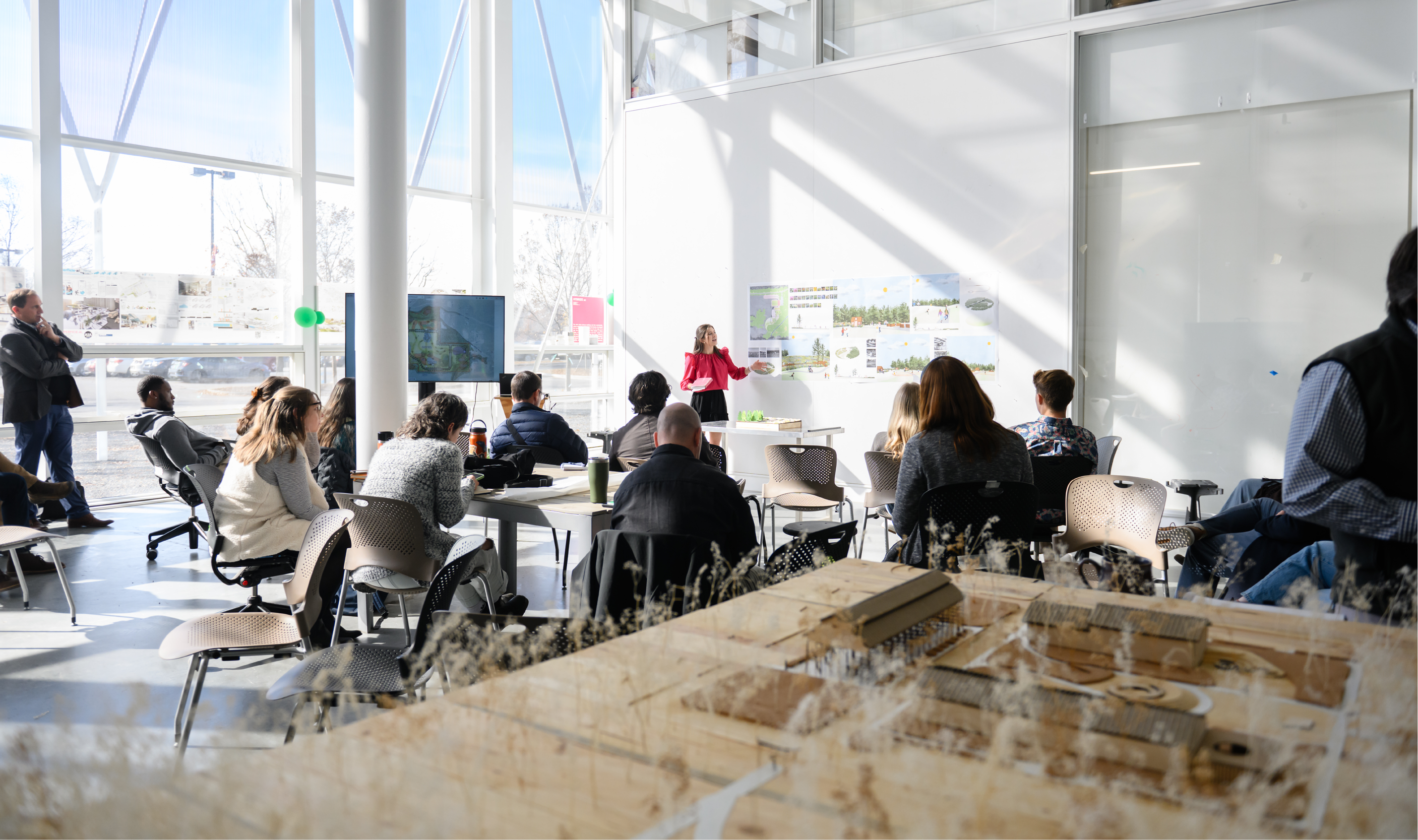 Student presenting to a room of faculty and students.