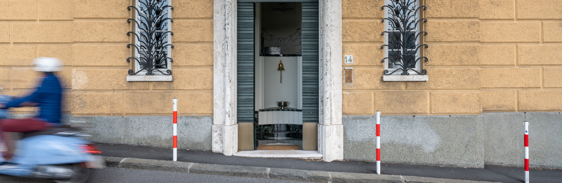 front door of the Villa with a vespa speeding by