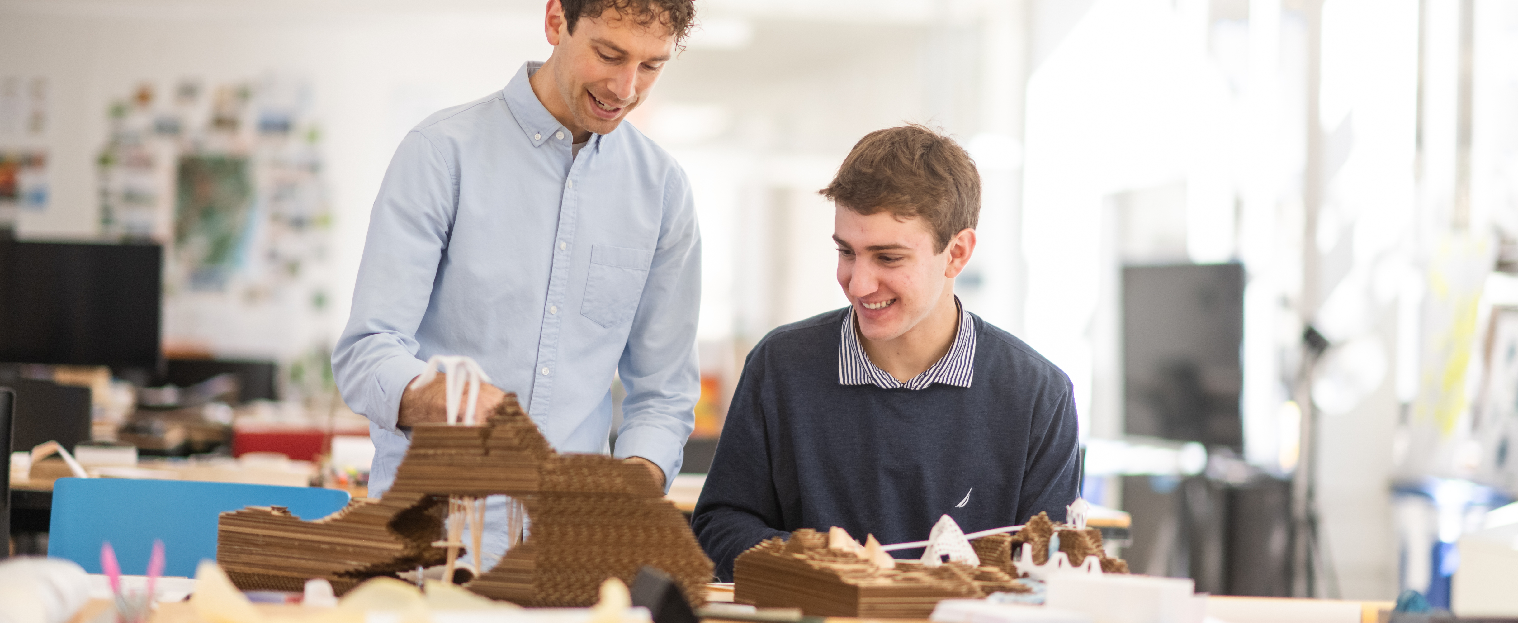 Male student and male teacher working together on a project. 