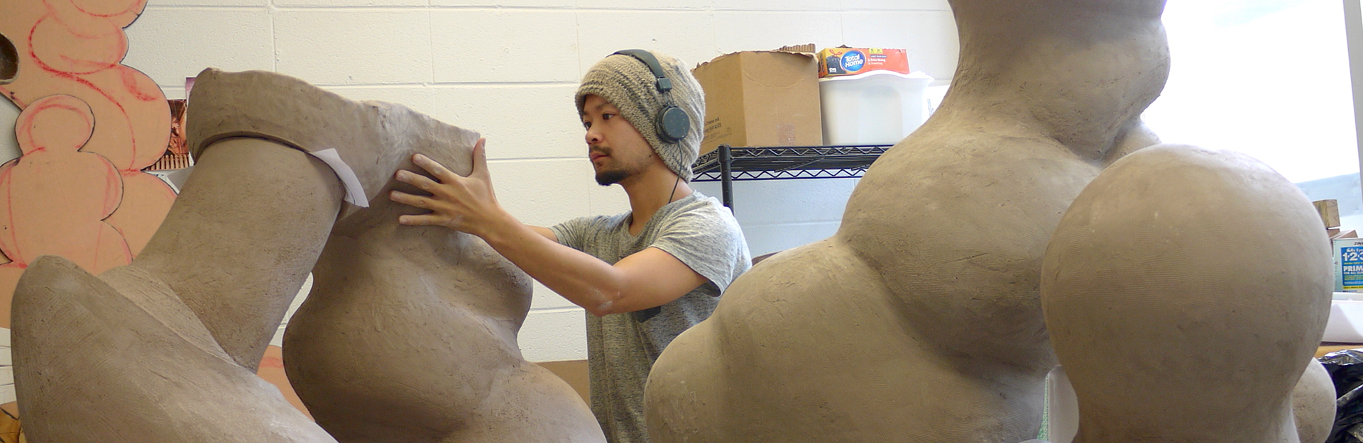 Art alumni places a large rounded sculpture