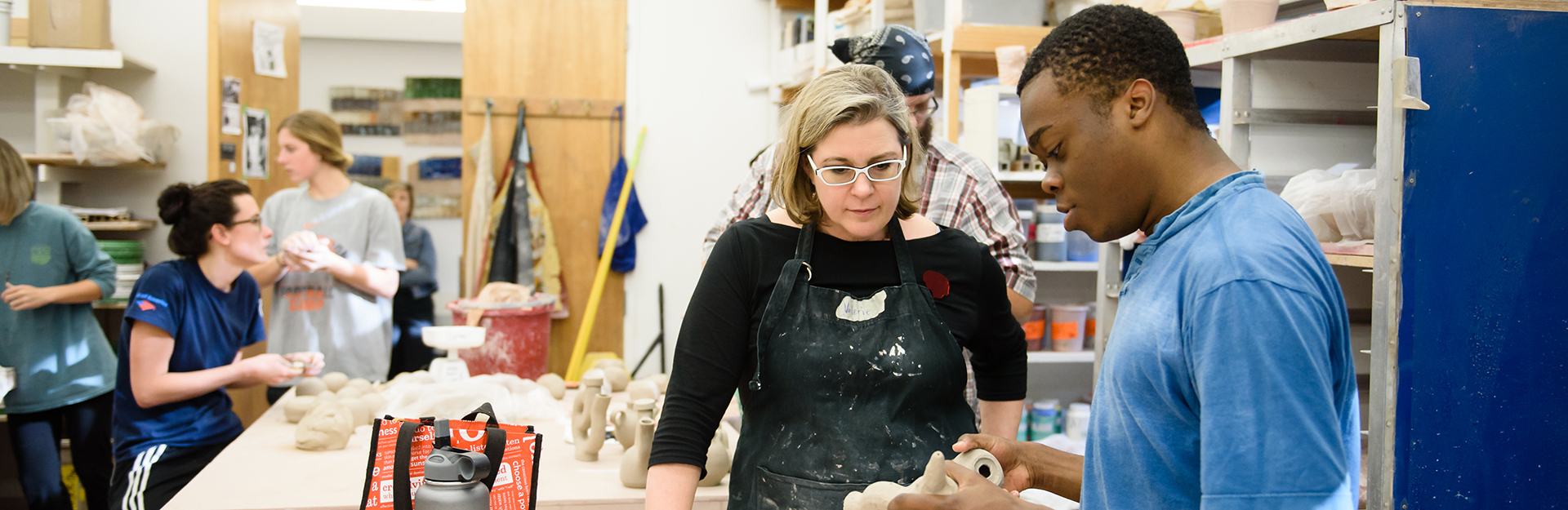 Art professor and student examine ceramic art