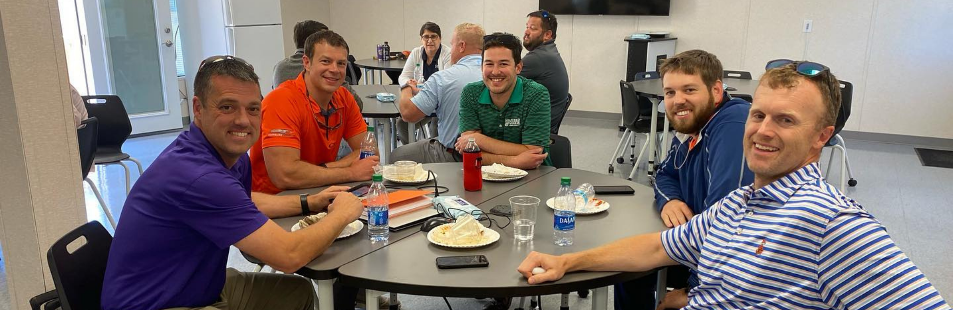 group of men sitting around a table smiling