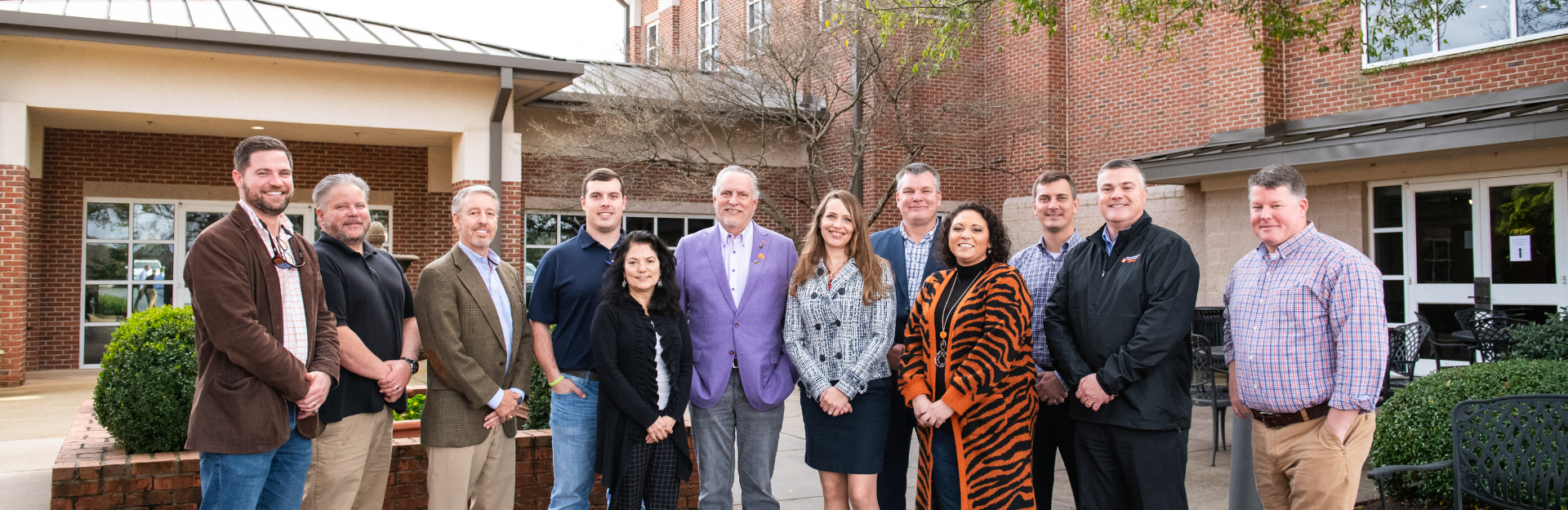 Industry Advisory Board pose for a photo outside. Group of men and women smiling in a group.