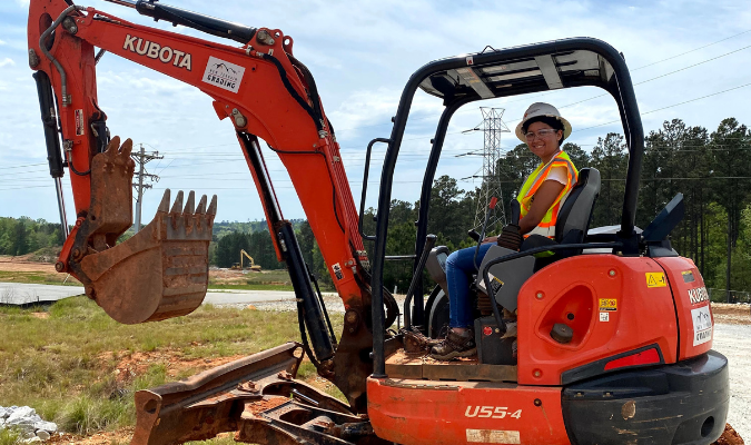 Female CSM student working on a piece of equipment at the XL Yard