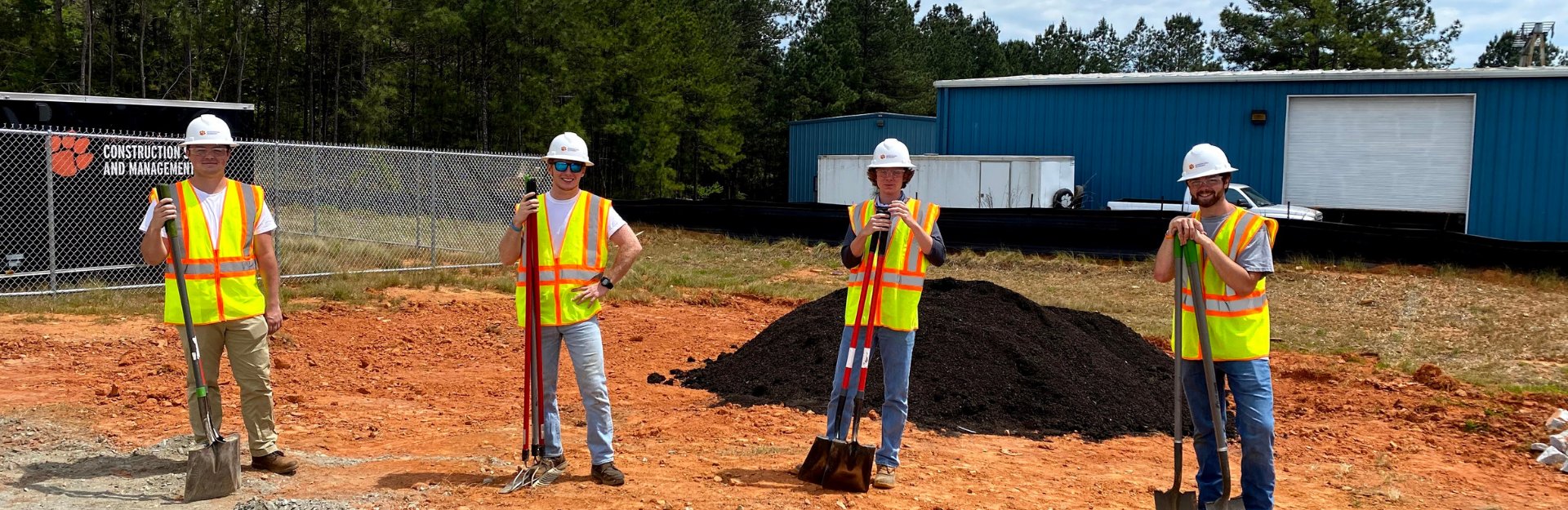 students pose on construction site