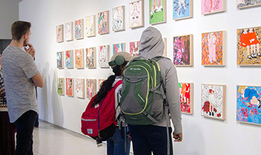 students viewing paintings in art gallery