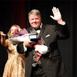 A person waving wearing a suit