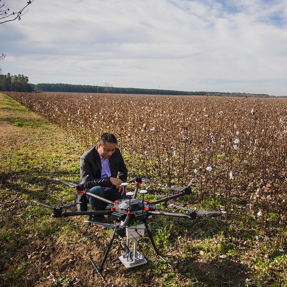 joe mari maja working with a drone near crops