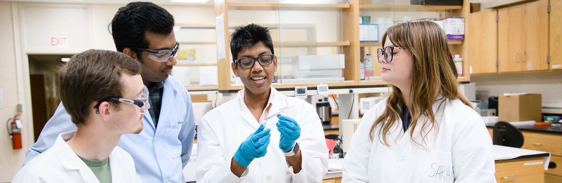 a group of research students looking at a sample