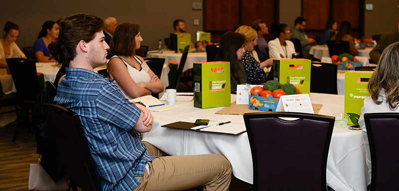 a group of people listening to a presenter speak