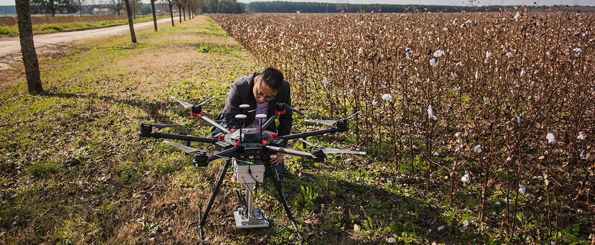 Joe Mari Maja with agri-tronic device beside a cotton field