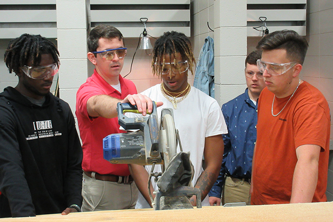 students learning how to utilize a chop saw