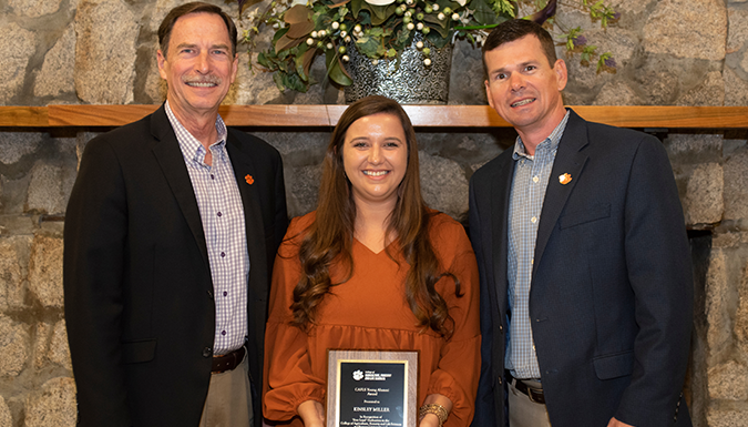 Dr Belli and Ben Skelley posing with Kisley Miller and her award plaque