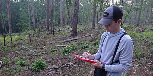 person writing on clipboard